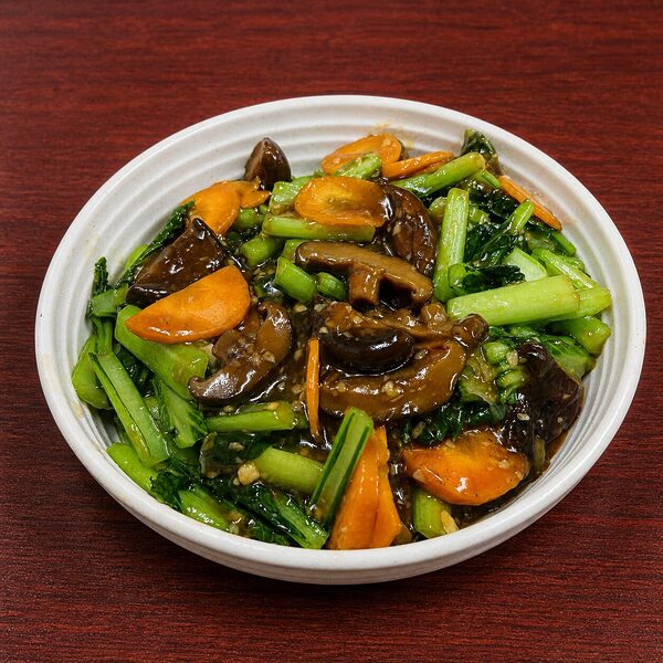 Stir-fried gai lan with sliced shiitake mushrooms and carrots in a savory brown sauce