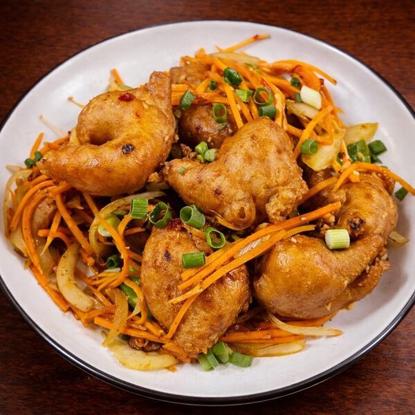 Crispy fried shrimp served over a bed of sautéed carrots, onions, and green onions