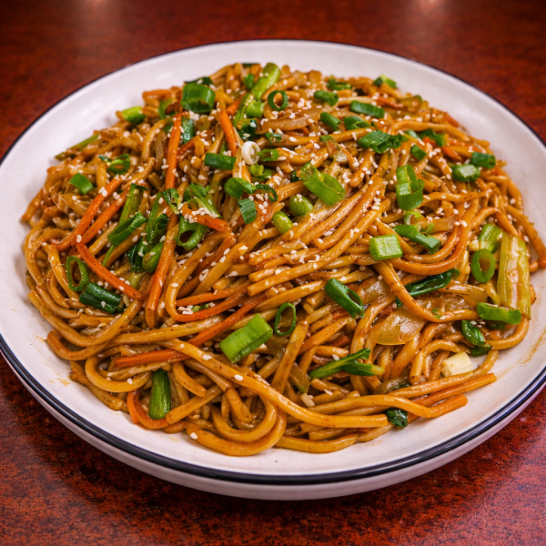 Stir-fried noodles with carrots, green onions, and sesame seeds on a white plate