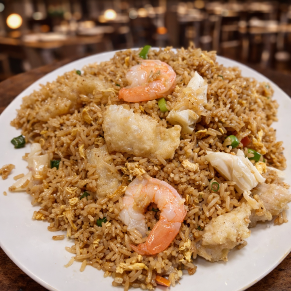 Plate of shrimp and fish fried rice with egg and scallions