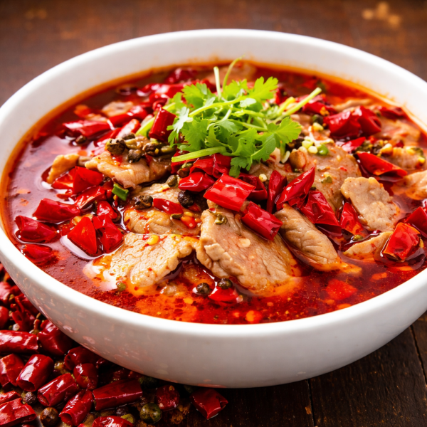 Bowl of spicy Sichuan boiled beef with dried red chili peppers, peppercorns, and cilantro