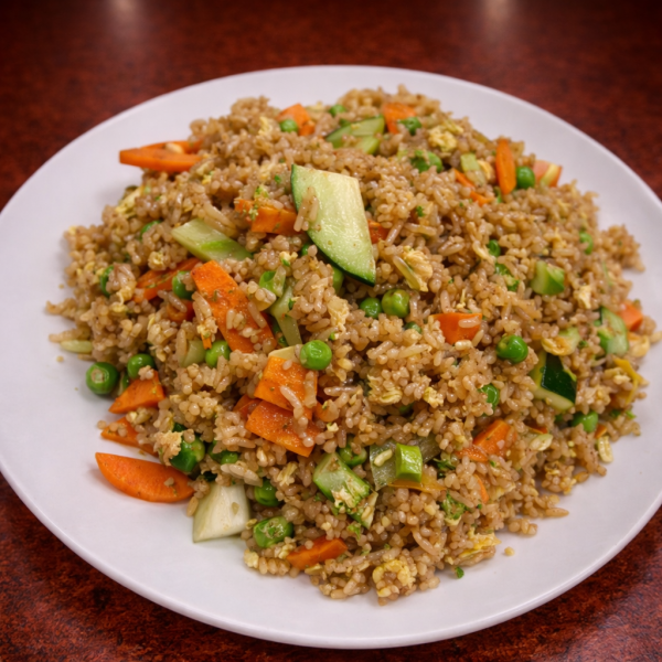 A plate of vegetable fried rice with carrots, peas, and cucumber