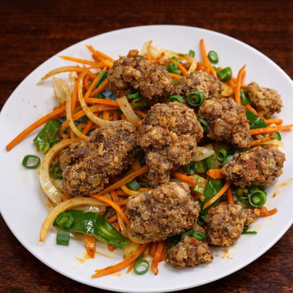 Crispy fried meat pieces served over a stir-fry of julienned carrots, onions, green peppers, and scallions